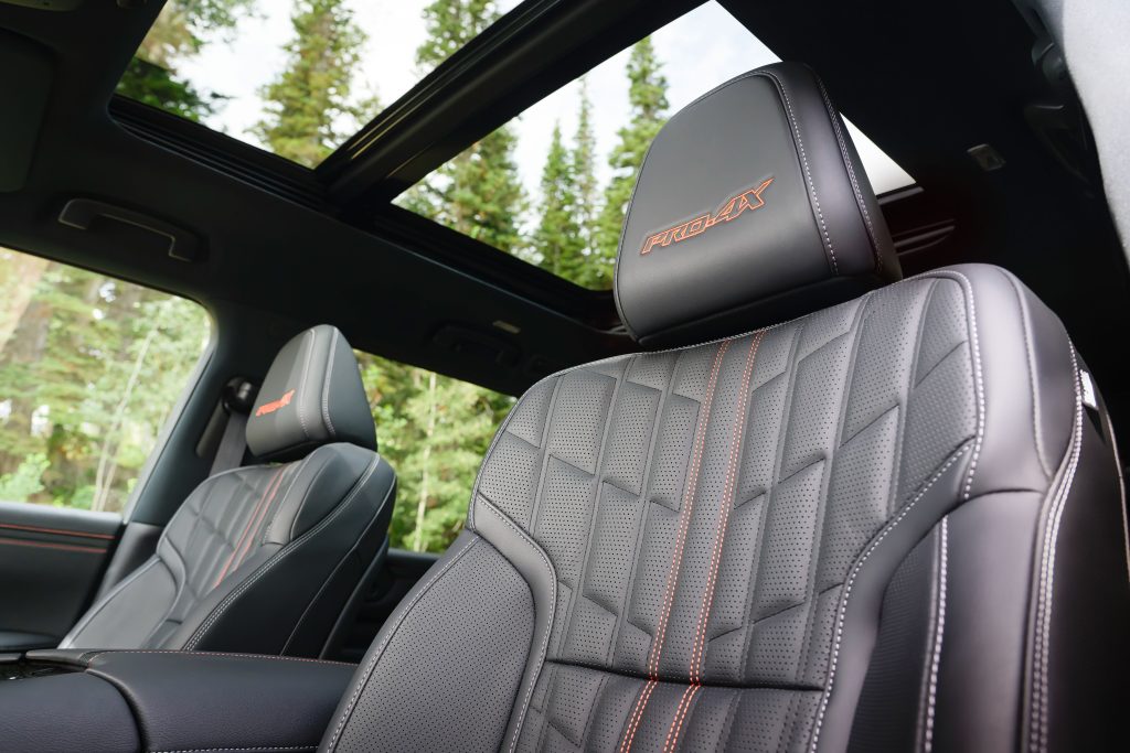 Close-up of the 2025 Nissan Armada PRO-4X quilted leather seats with orange stitching and panoramic sunroof.