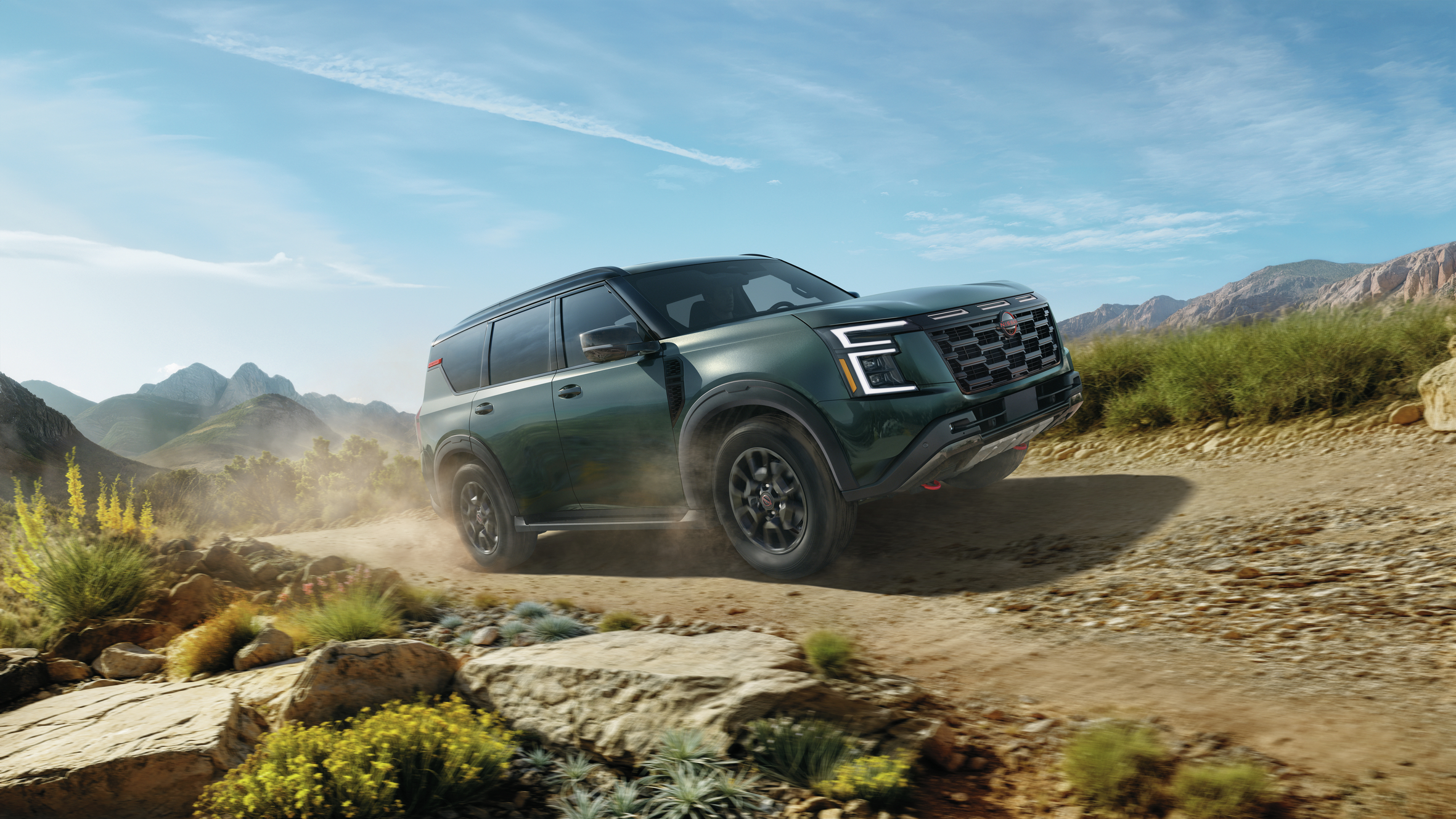 2025 Nissan Armada parked on a scenic off-road trail, showcasing its rugged Pro-4X trim features and bold design.