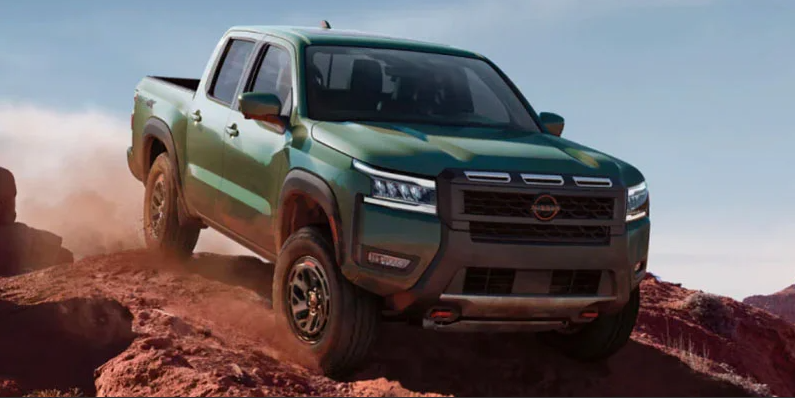 A green 2025 Nissan Frontier off-roading.