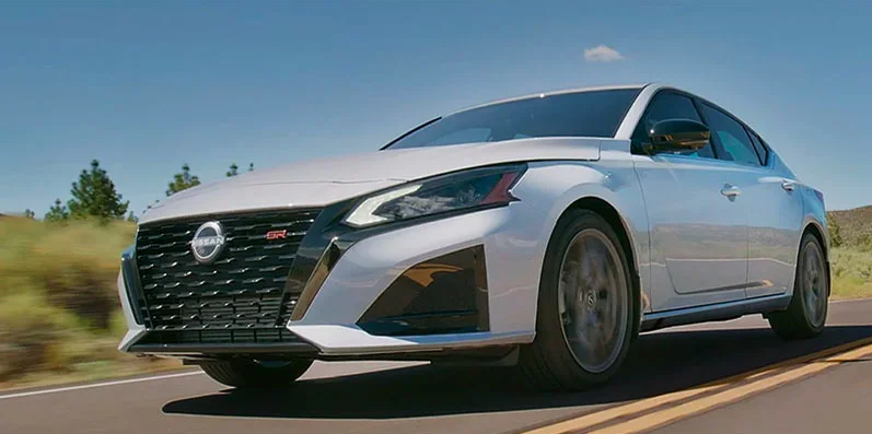 A white 2025 Nissan Altima driving down the road.
