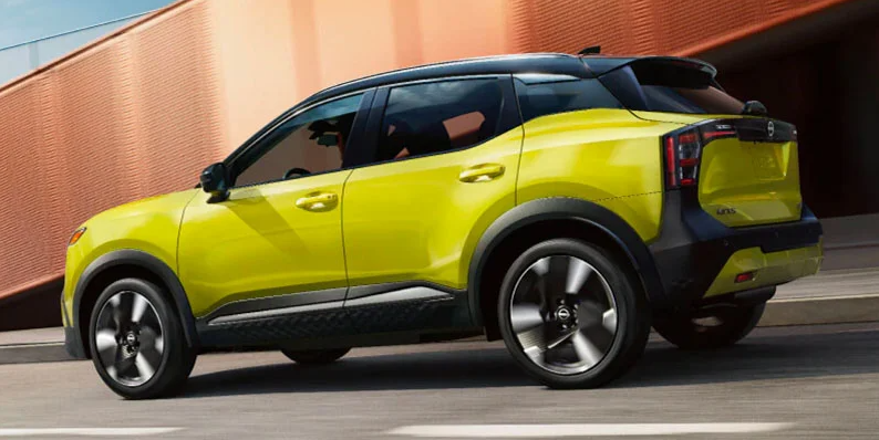 A yellow 2025 Nissan Kicks driving down the road.
